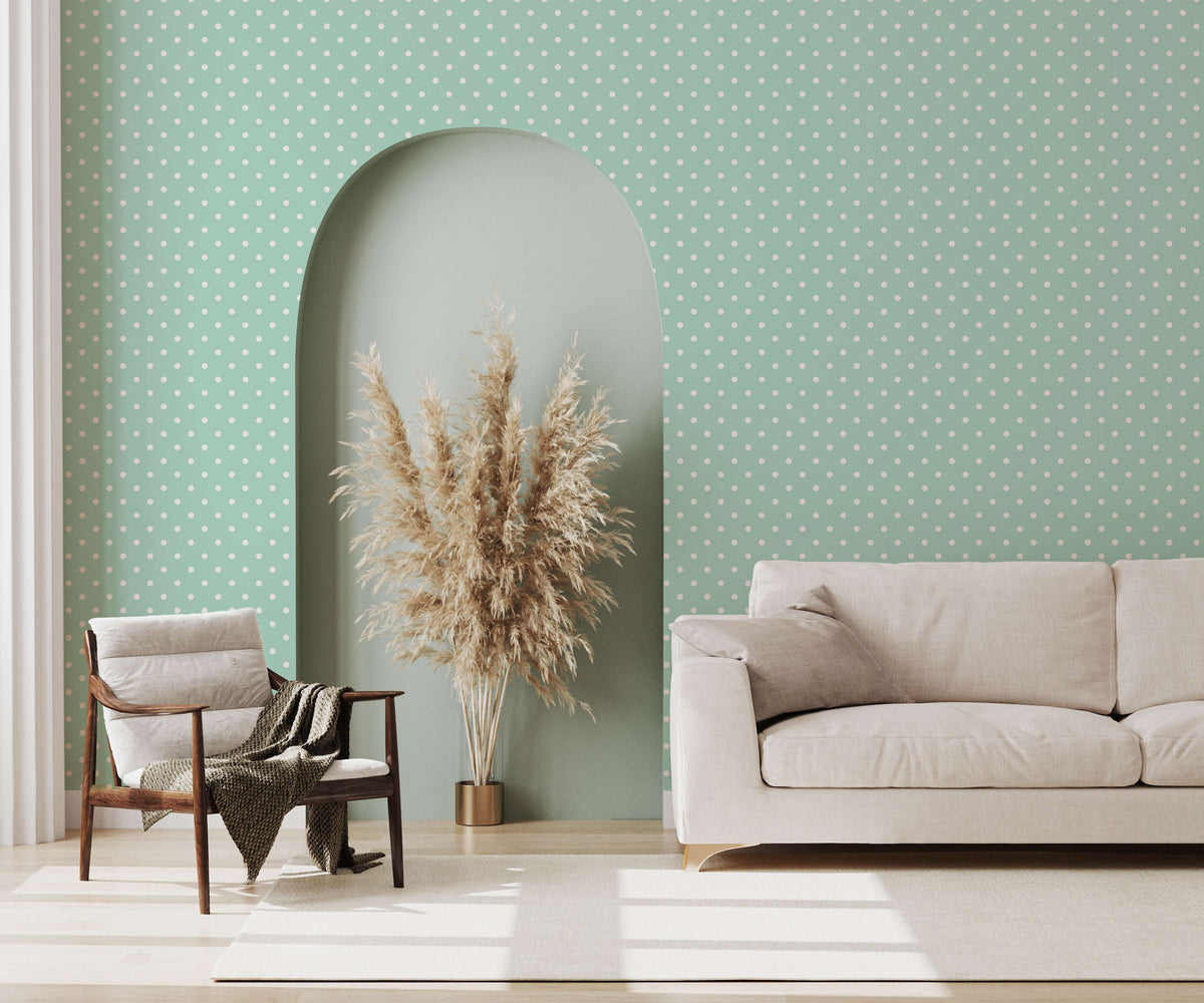 Beige upholstered bonbon sofa with clean lines and matching cushions against a polka dot wallpaper background