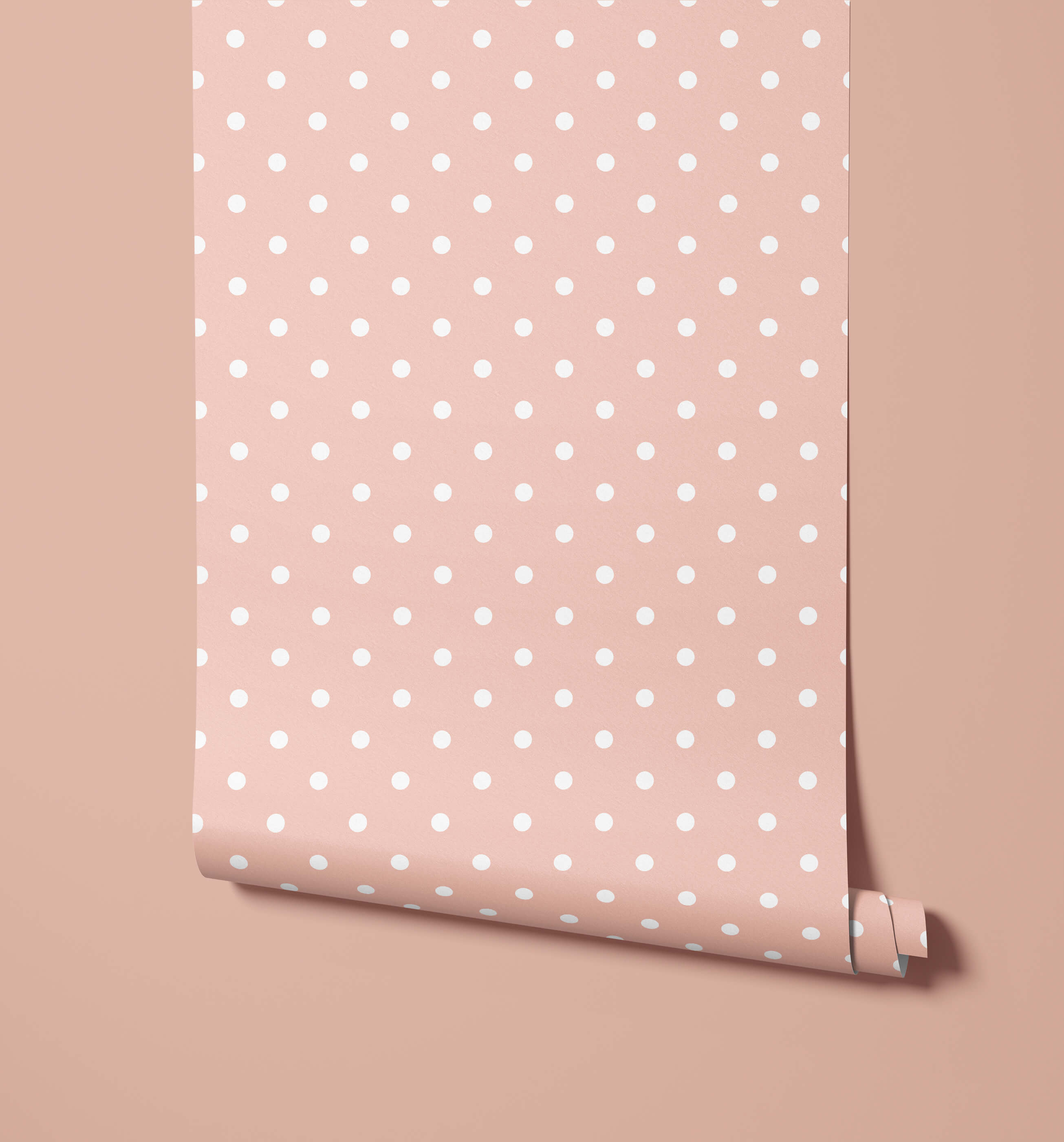 A roll of bonbon soft pink polka dot wallpaper with evenly spaced white dots for stylish wall decor
