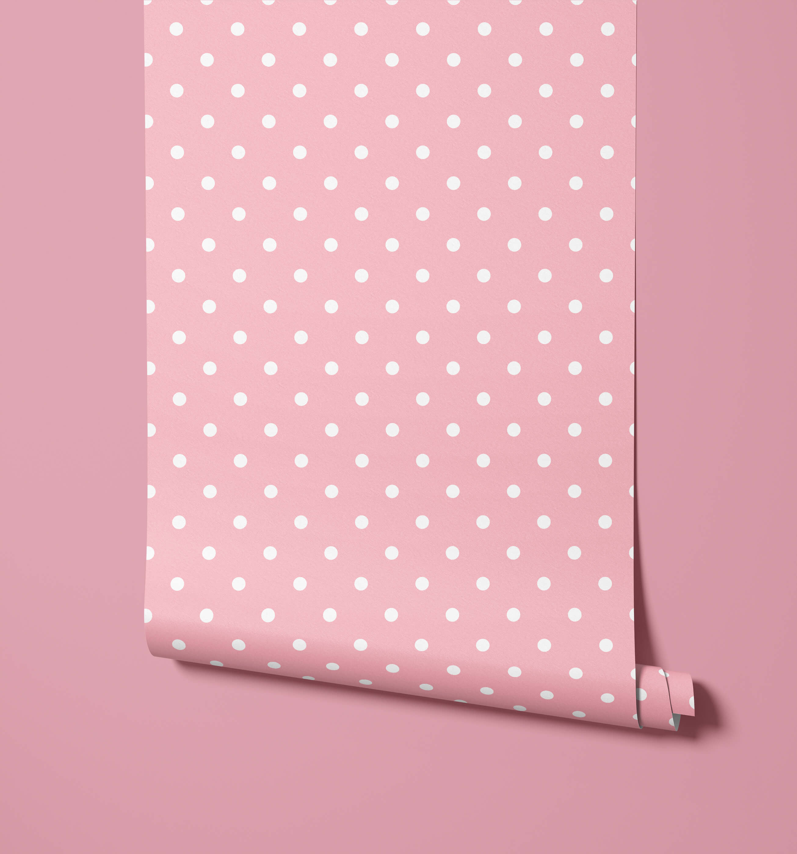 Pink bonbon polka dot wallpaper with white dots and a rolled bottom edge for fun dot wallpaper decor