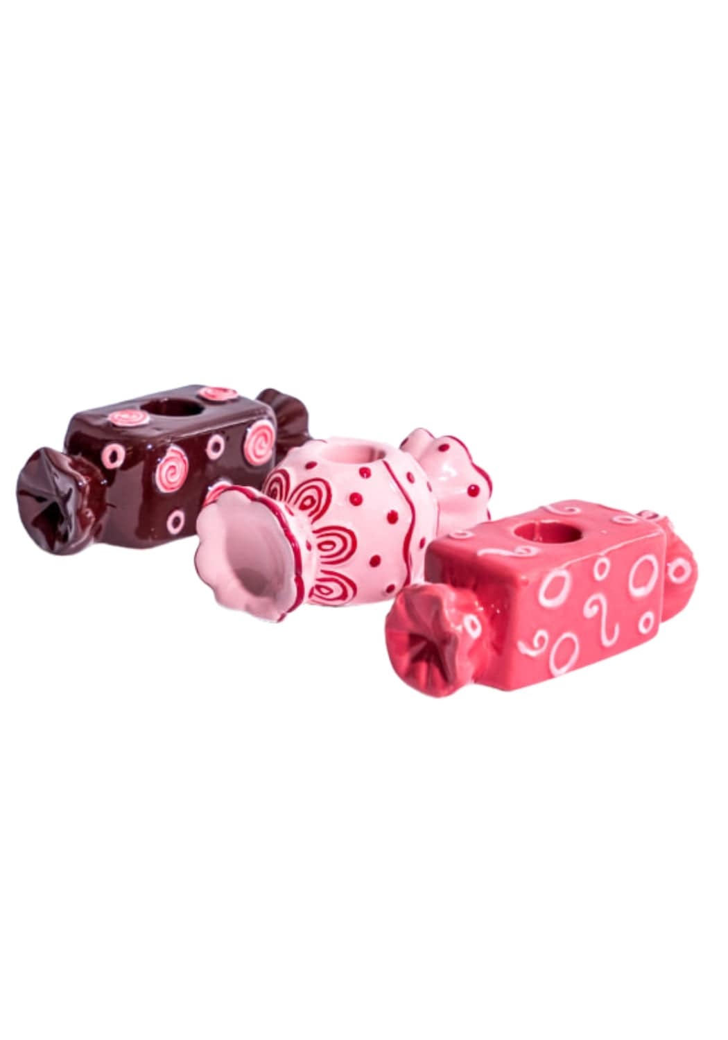 Three ceramic candy shaped bonbon tea light holders in pink and red with glossy finish and decorative swirls