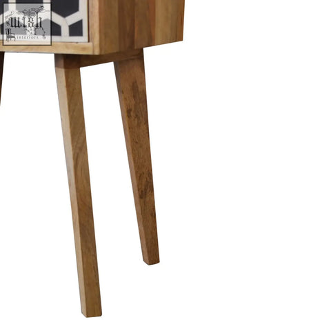 A mid-century modern nightstand with bone inlay drawer and tapered legs made from solid mango wood in oak-ish finish