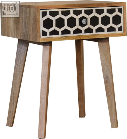 A modern tapered bedside table in solid mango wood with bone inlay geometric drawer pattern in black and white