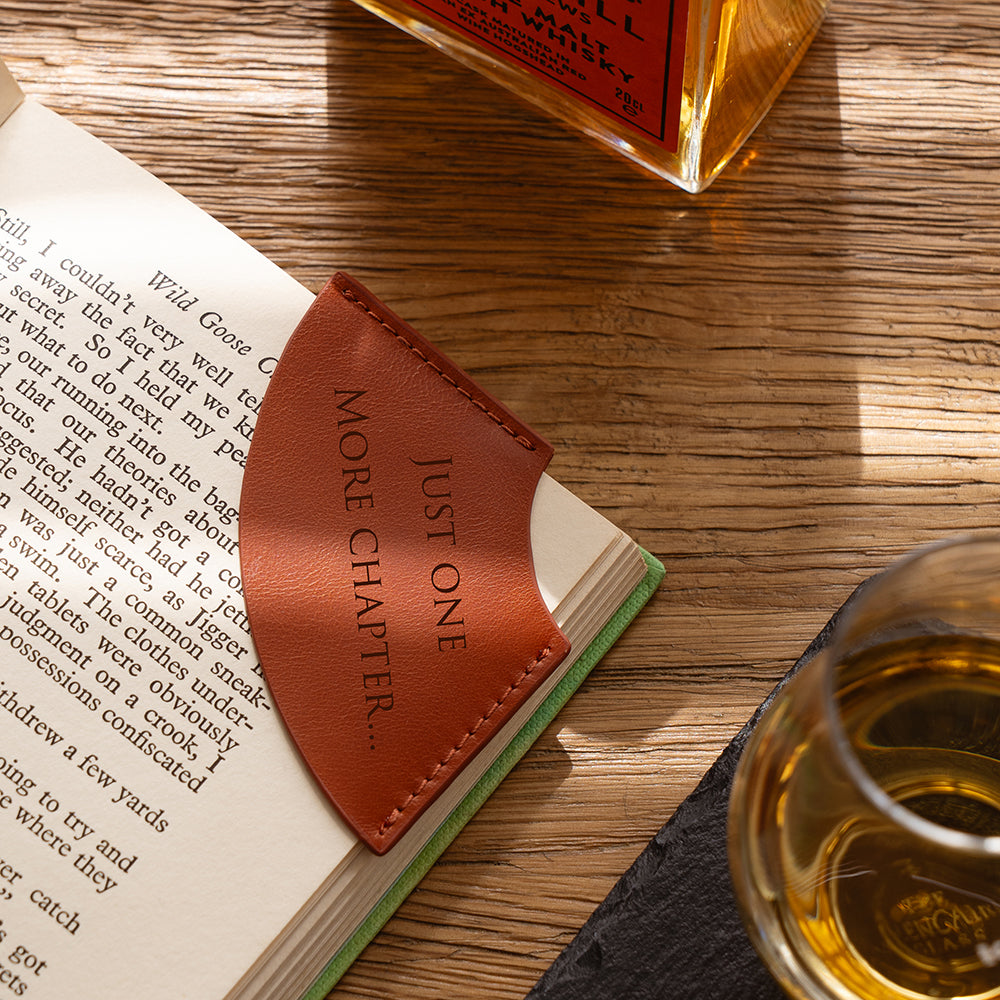 Brown leather corner bookmark embossed with just one more chapter text for book lovers and readers