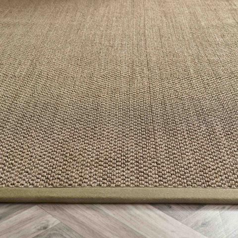 Beige woven bordered sage green sisal rug with textured tightly knitted surface and matching border