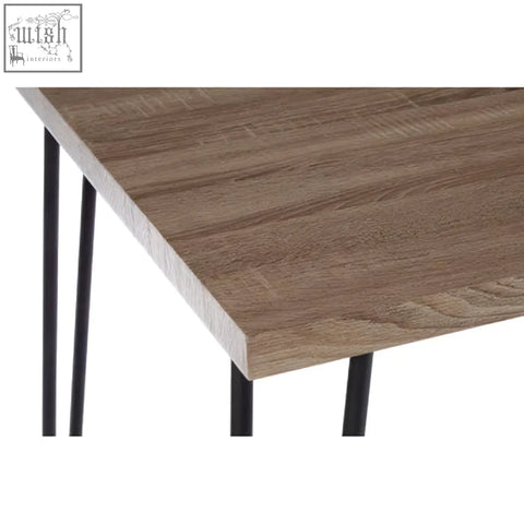 A modern dining table with a brown wood effect veneer top and black finish metal hairpin legs