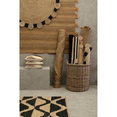 Large natural and black jute rug with woven geometric pattern and black circular accents perfect for living rooms