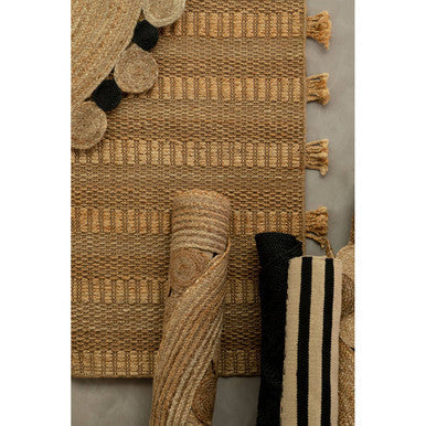 Large natural and black jute rug with natural woven striped pattern and tassels along the edge black jute rug