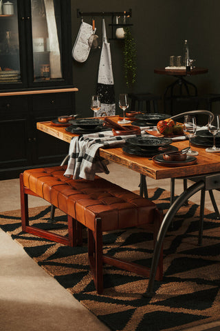 Brown tufted leather dining bench with wooden legs shown on a bosie hemp large rug for stylish dining spaces