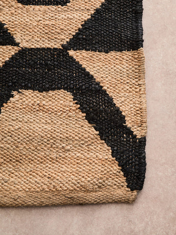 Bosie hemp large rug featuring a bold black and beige geometric pattern made from textured jute fibers