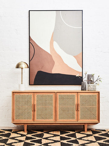 A mid-century modern sideboard with light wood frame and cane-paneled doors shown next to a bosie hemp large rug