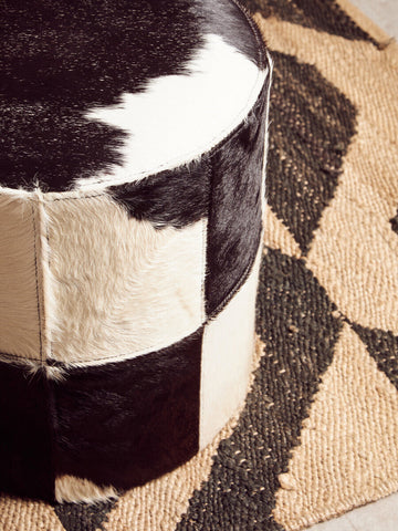 Black and white cowhide patchwork ottoman paired with bosie hemp small rug for stylish small rug decor
