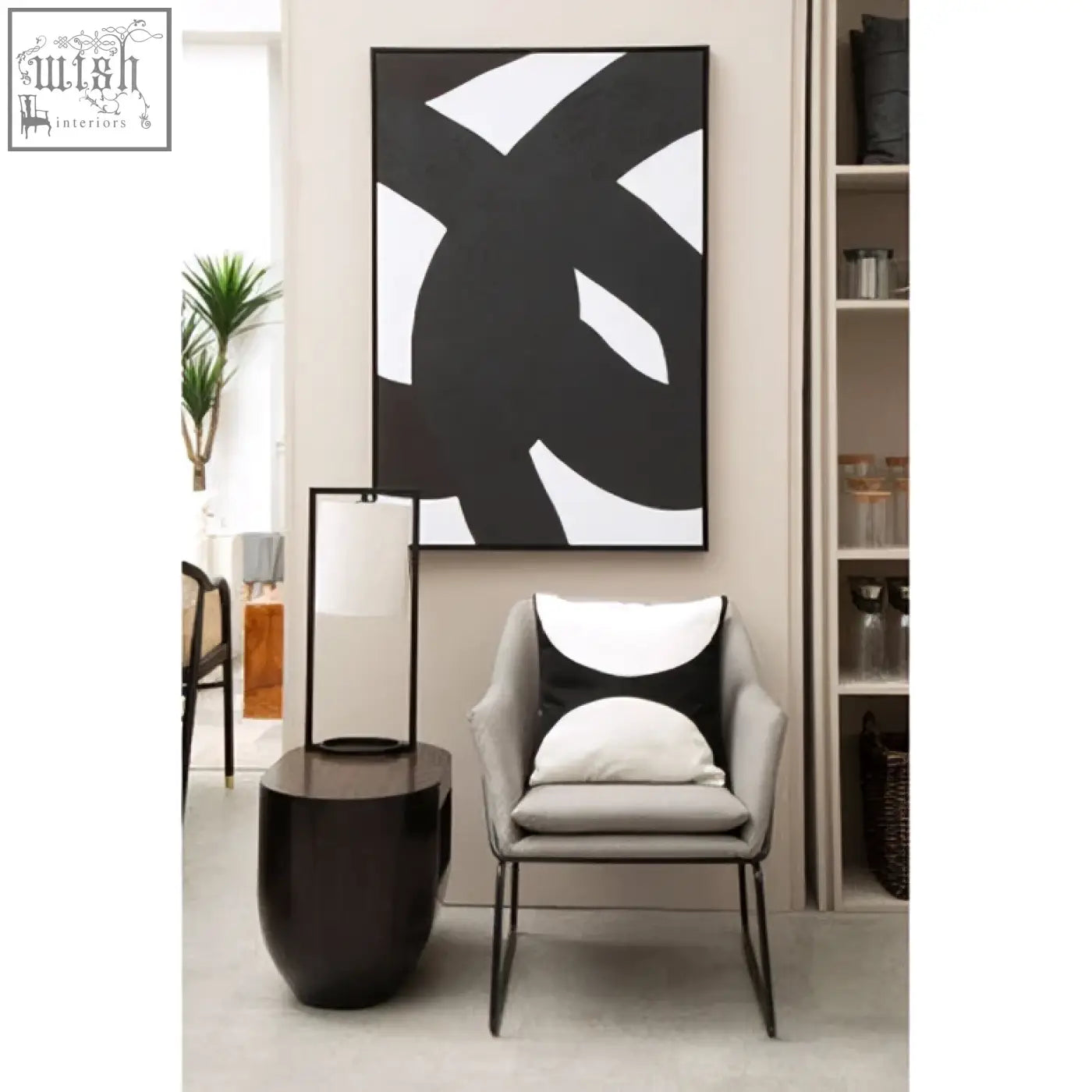 Gray armchair with black metal legs and a bosie ozella black and white semi circular design cushion on it