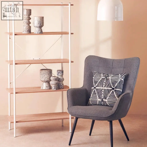 Gray upholstered armchair with bosie ozella black and white square embroidered cushion featuring geometric pattern
