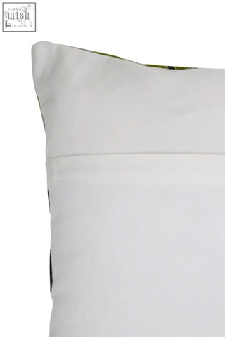 White pillow with subtle textured fabric and faint green pattern on top edge in bosie ozella botanical green cushion