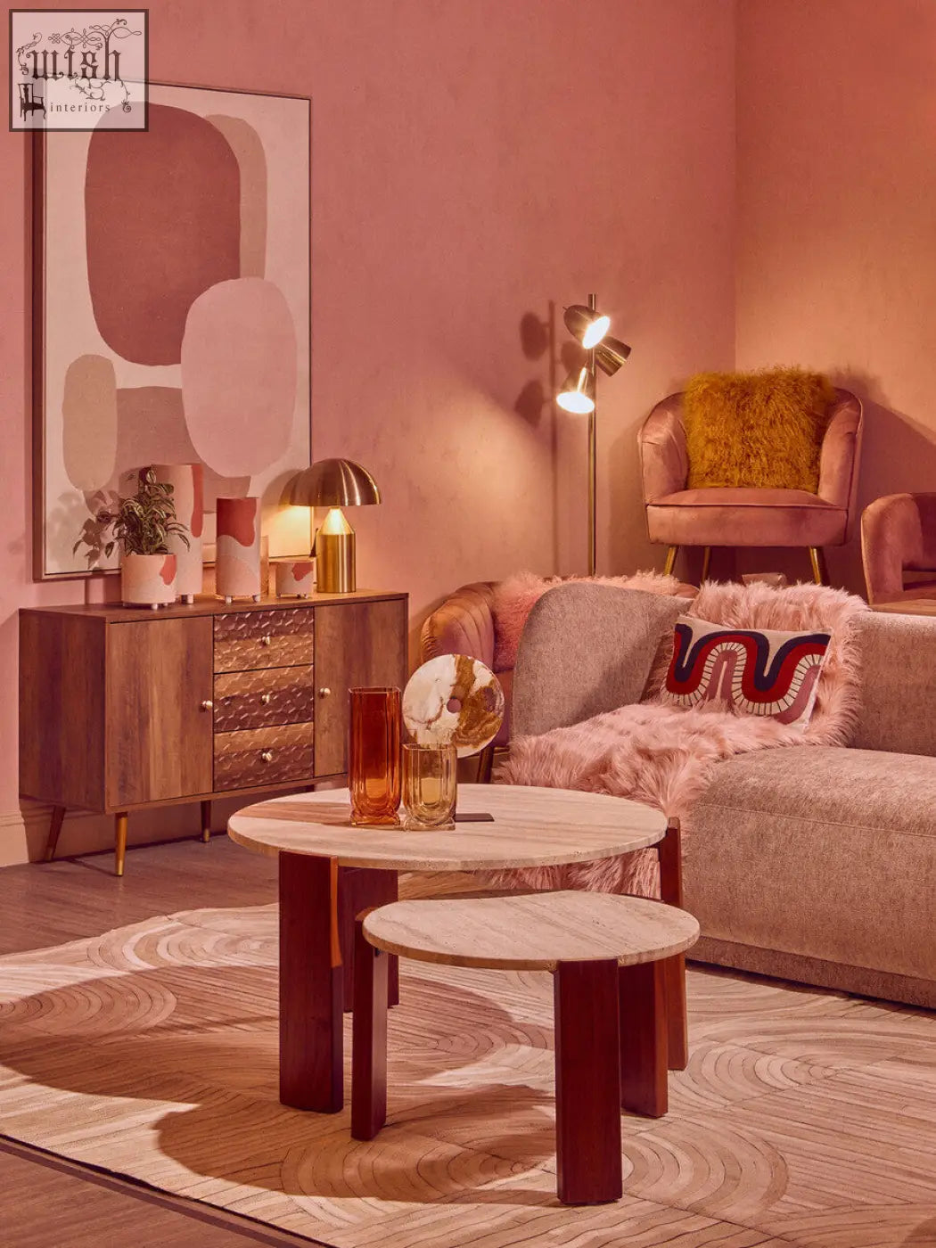 A pair of nested round coffee tables with light marble tops and dark wooden legs next to an ozella curve pattern rectangular cushion