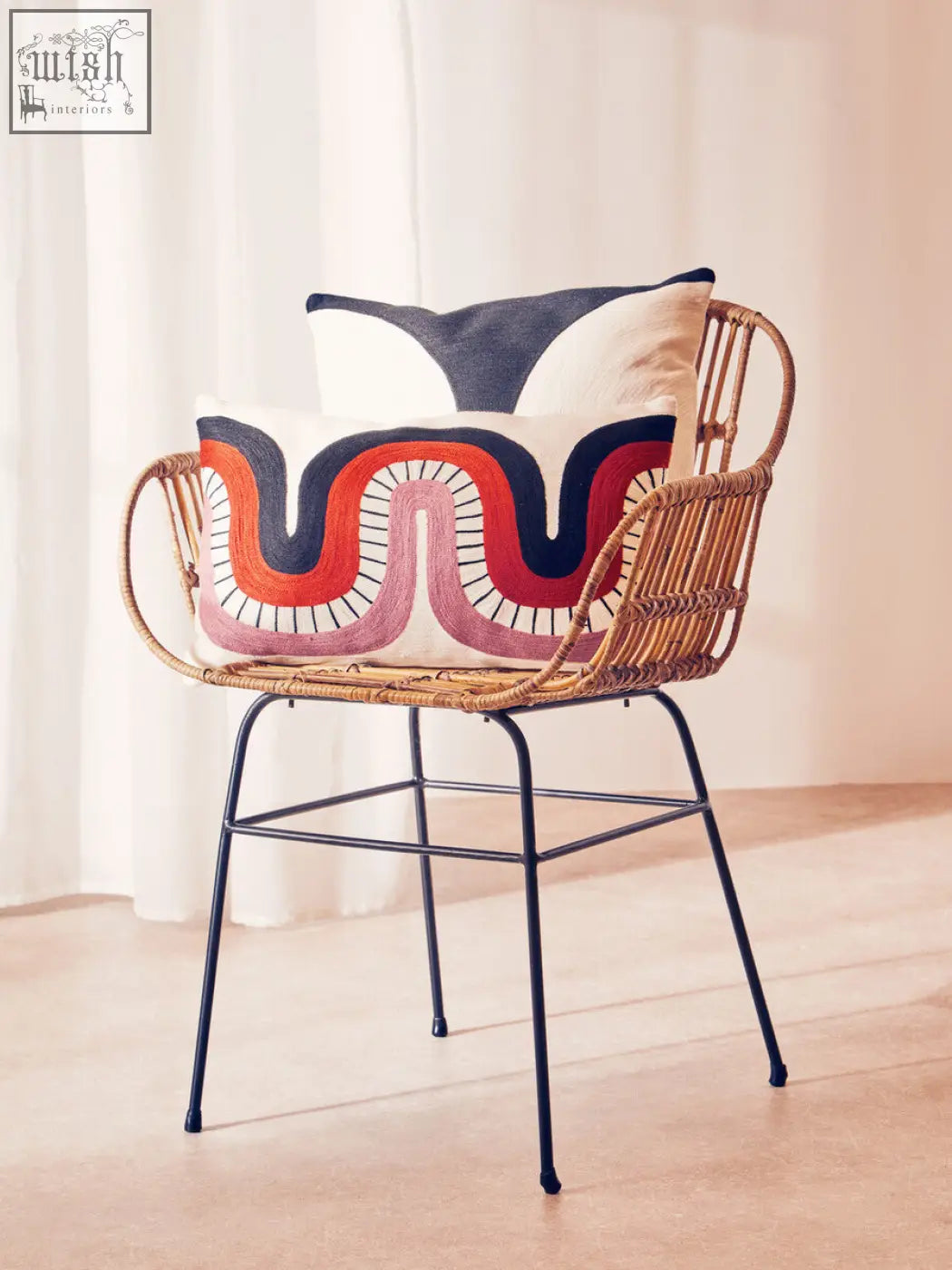 Woven rattan chair with black metal legs and colorful ozella curve pattern rectangular cushion on its seat