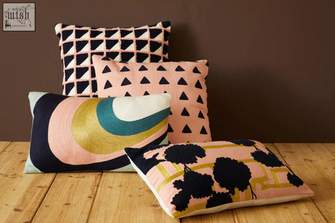 Set of four bosie ozella curved stripes cushions with bold pink black gold teal and navy geometric patterns on textured fabric