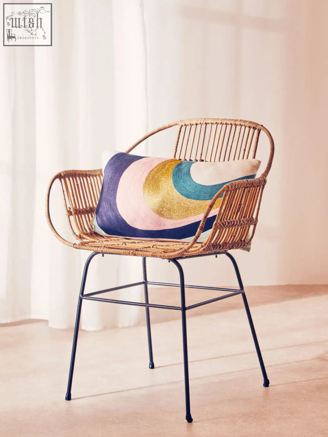 Woven rattan chair with black metal legs featuring a bosie ozella curved stripes cushion in bright colors