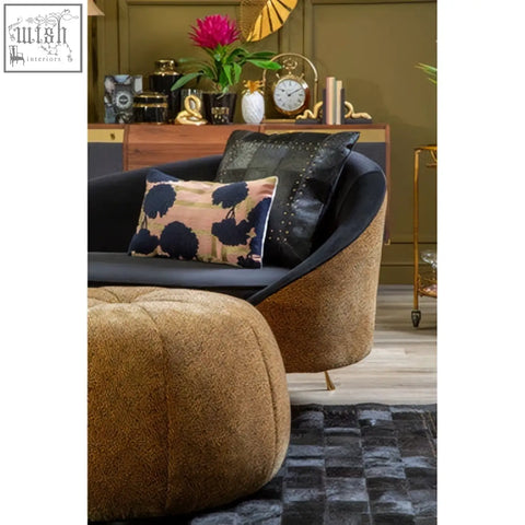Black upholstered armchair with tufted back featuring a bosie ozella floral design cushion in vibrant colors
