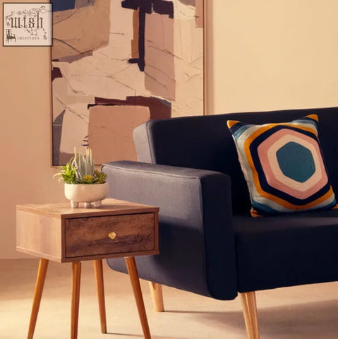 Navy blue velvet sofa with bosie ozella hexagonal design cushion featuring teal orange and cream geometric pattern