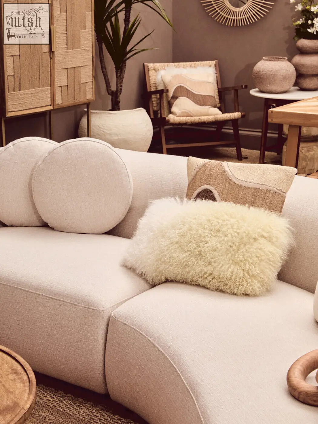 Beige modular sectional sofa with plush circular and fluffy sheepskin bosie ozella natural tonal cushion pillows