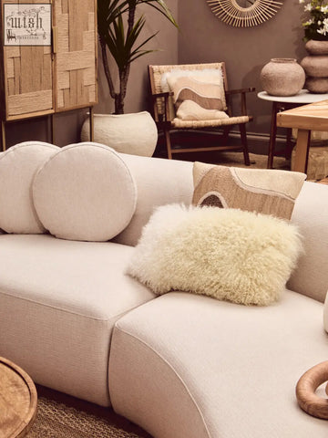 Beige modular sectional sofa with plush circular and fluffy sheepskin bosie ozella natural tonal cushion pillows