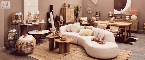 Cream-colored curved sectional sofa with plush natural tonal cushions in minimalist bosie ozella design