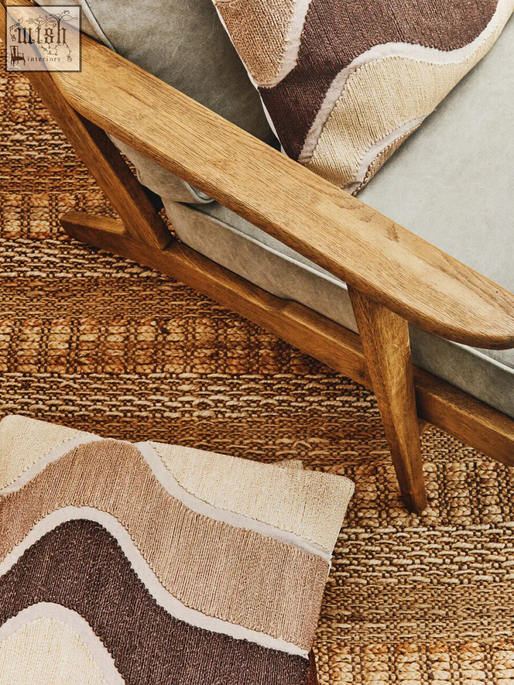 A wooden armchair with a light natural finish featuring a bosie ozella natural tonal cushion in soft tones