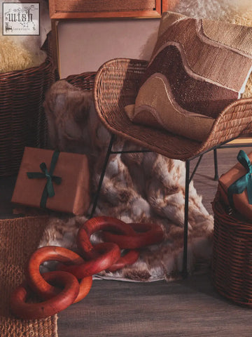 Woven wicker chair with bosie ozella natural tonal cushion in earth tones and abstract wave pattern