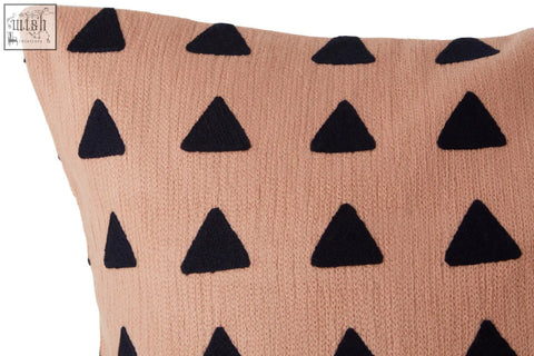 A bosie ozella pink knit cushion featuring a blush pink base with black embroidered triangle patterns