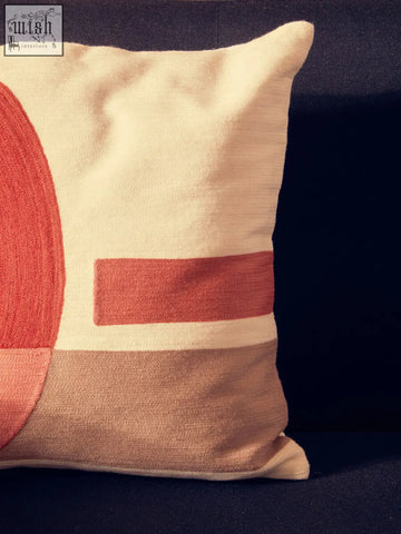 Cream-colored bosie ozella tonal cushion with coral-red semicircle and white tonal stripe accents
