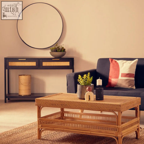 Natural-toned rattan coffee table with woven top and open shelf paired with bosie ozella red and white tonal cushion
