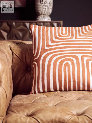 Bosie ozella white cushion with orange and white geometric pattern and intricate embroidery on front side