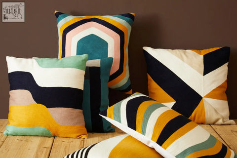 A bosie ozella stripes design cushion with colorful geometric patterns in teal mustard yellow navy blue and cream