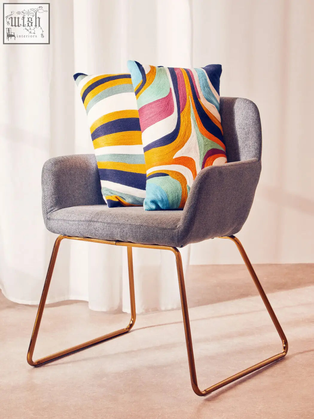 Gray upholstered armchair with gold metal legs and bosie ozella stripes design cushion in colorful abstract print