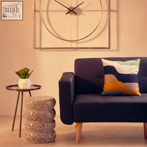 Navy sofa with wooden legs featuring a bosie ozella wavy stripes cushion in orange teal white and gray stripes cushion