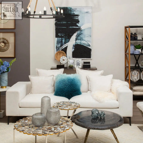 White upholstered sofa with a plush bosie real mongolian fur blue ombre square cushion and fluffy white pillows
