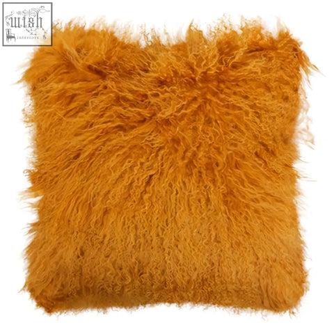 A bosie real mongolian lamb fur ochre square cushion with shaggy, fluffy, vibrant orange lamb fur texture
