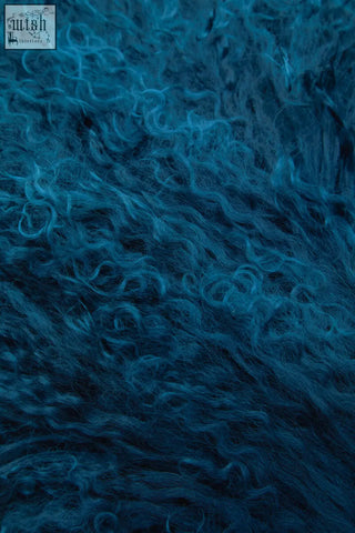 Deep blue bosie rectangular cushion made of plush curly mongolian lamb fur with a soft textured surface