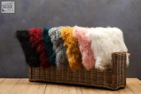 A collection of vibrant lamb fur throw blankets including teal bosie real mongolian fur square cushion displayed on wicker bench