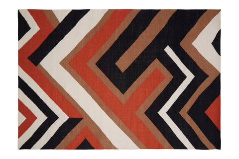 A bosie villon zig zag pattern rug with bold black orange white and tan chevron design on a rectangular surface