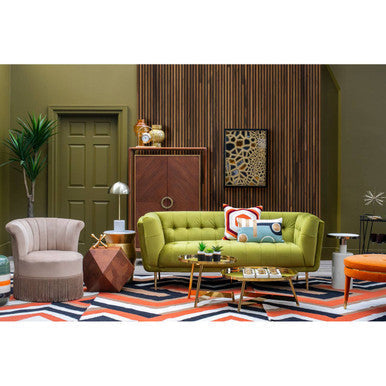 Vibrant green tufted sofa with plush cushions paired with bosie villon zig zag pattern rug in cozy living room setup