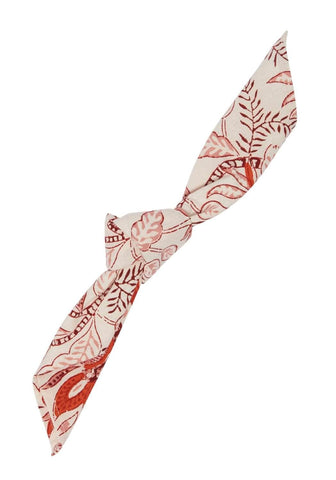 A cream fabric headband with a tied knot and rust botanical print complementing bossa nova table napkin set