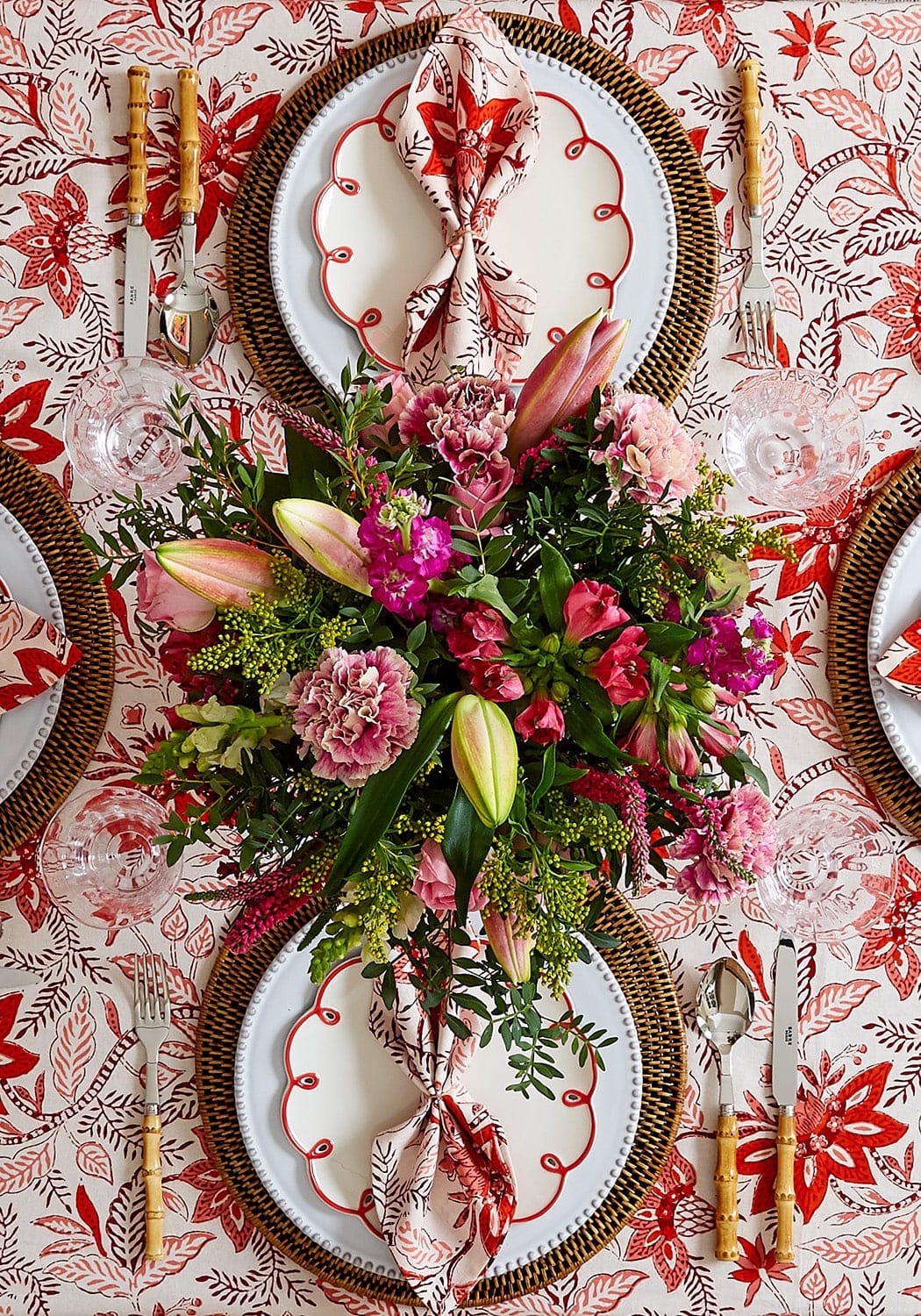 A vibrant floral centerpiece with pink magenta and green blossoms paired with bossa nova red table napkins set of 4