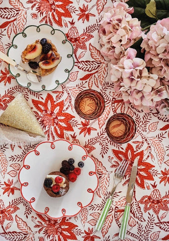 A white ceramic plate with a red decorative border and desserts on a bossa nova red tablecloth