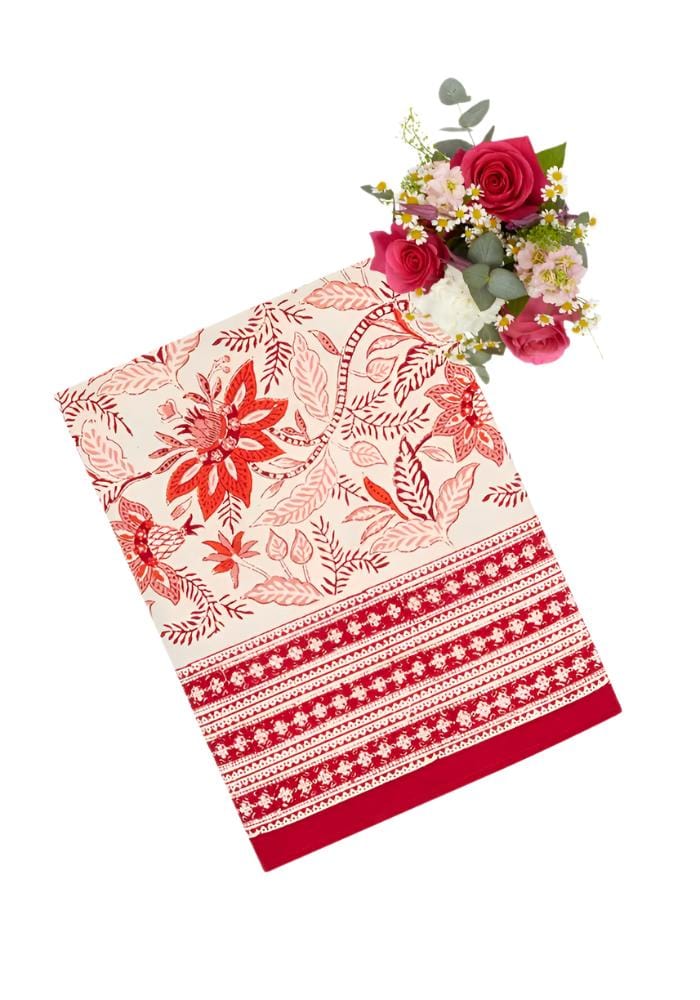 A cream cotton bossa nova table runner with vibrant red and maroon floral pattern and geometric borders