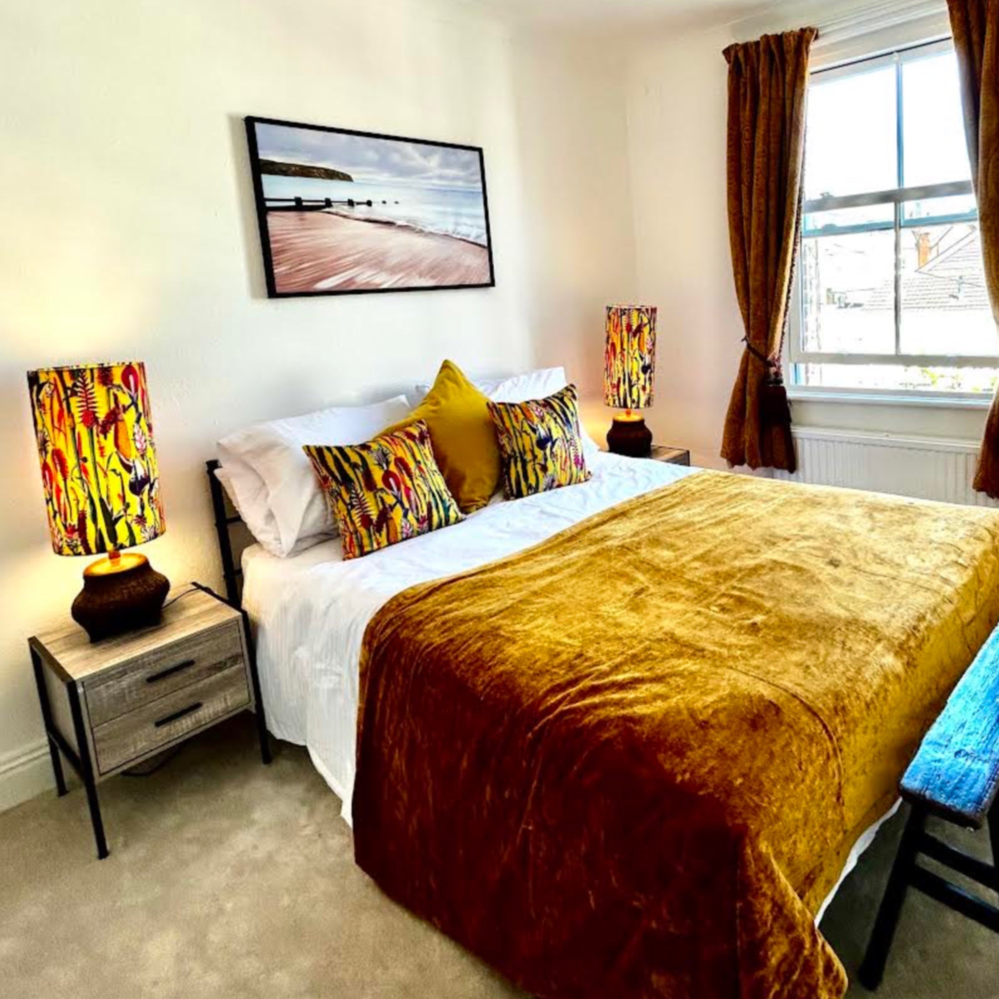 Golden velvet bedspread with plush textured surface shown behind botanical mustard velvet throw cushion