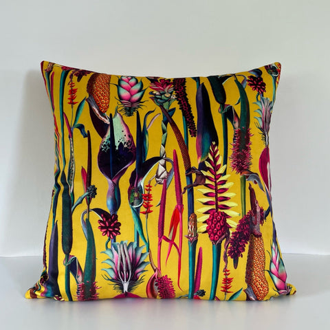 Vibrant botanical mustard velvet throw cushion with bold tropical floral print in pink purple green and red