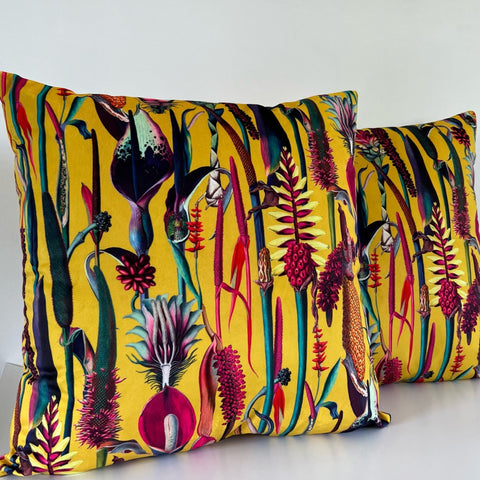 Vibrant yellow botanical mustard velvet throw cushion with bold tropical plants in deep purples reds and greens