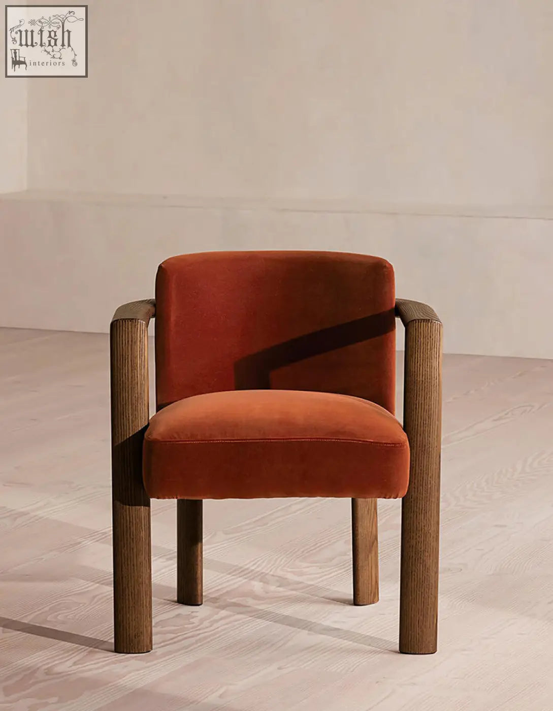 A cozy boucheron matching dining chair with rust-colored velvet upholstery and solid wood arms and legs for dining room